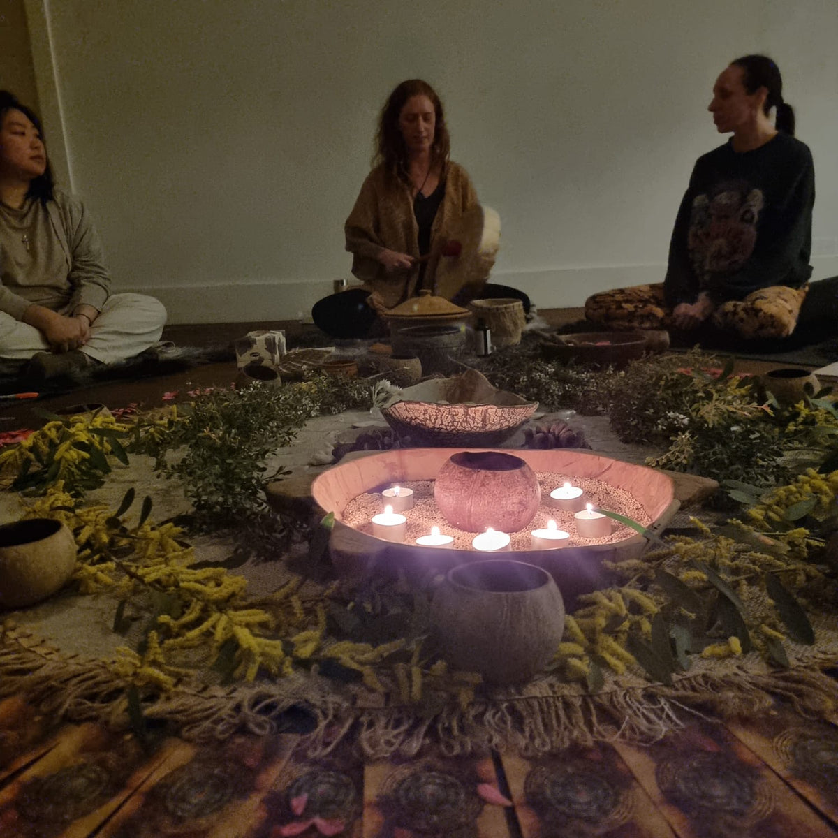 Sitting in circle around a candlelit altar