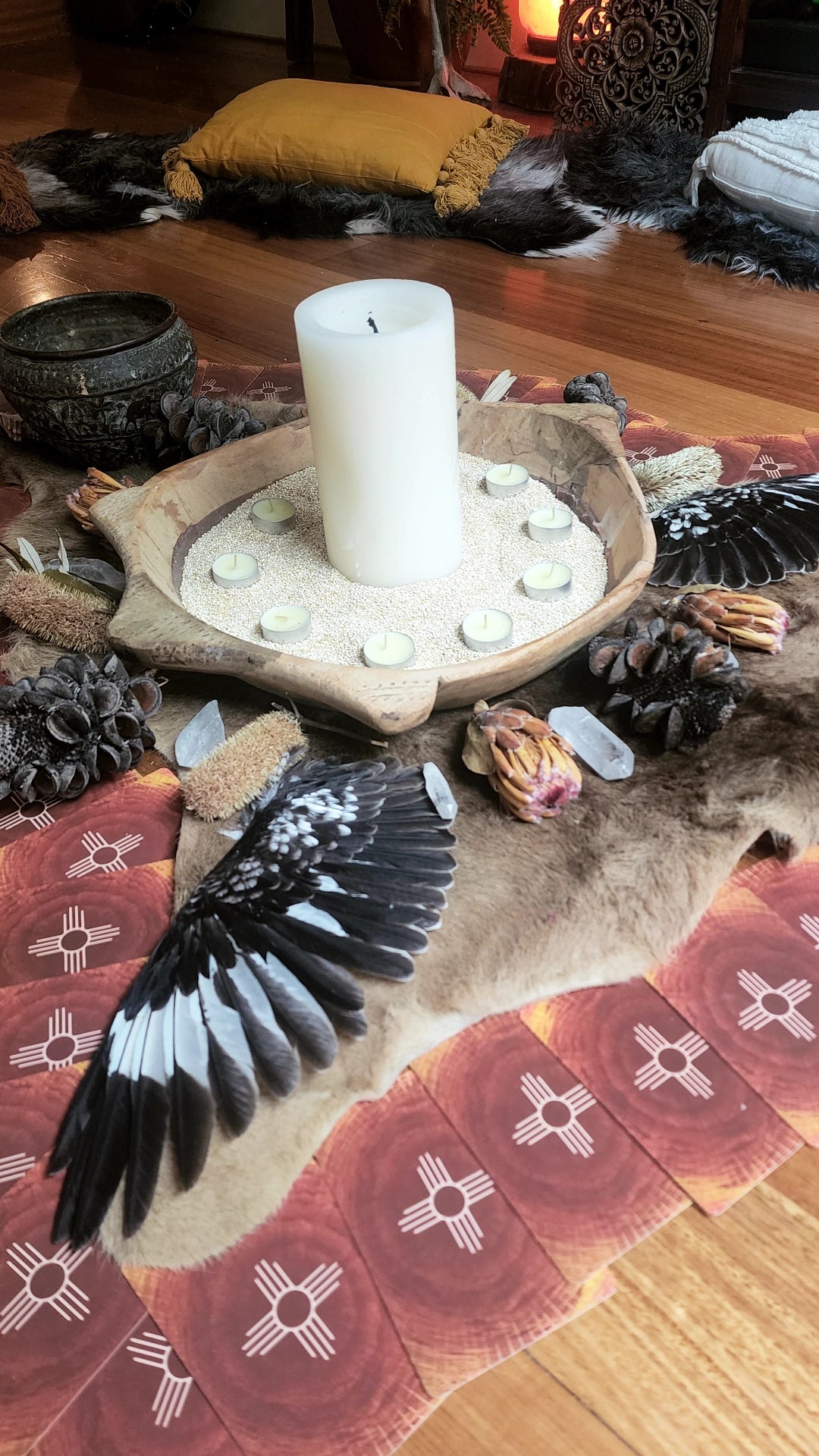 Altar with candle, feathers and pine cones
