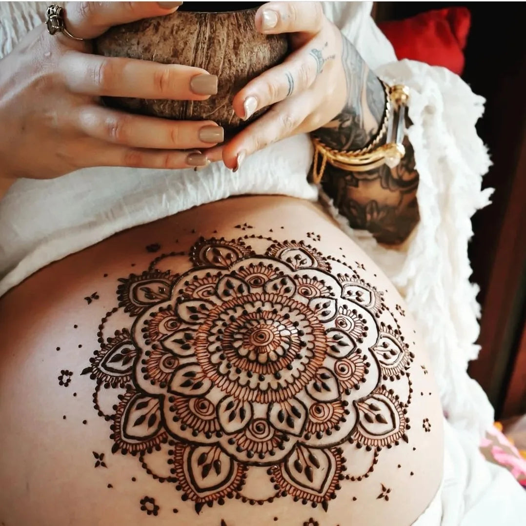 Henna on a pregnant belly with a cup of cacao